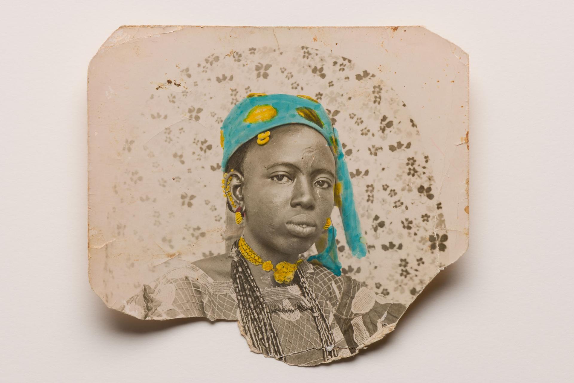 Photograph fragment showing a person in a blue headwrap and layered jewelry